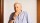 An older man pondering with his hand on his chin, contemplating effective altruism.