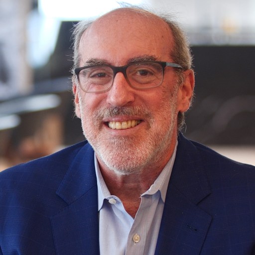 A man wearing glasses and a blue jacket.