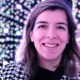 A woman smiling in front of a light display.