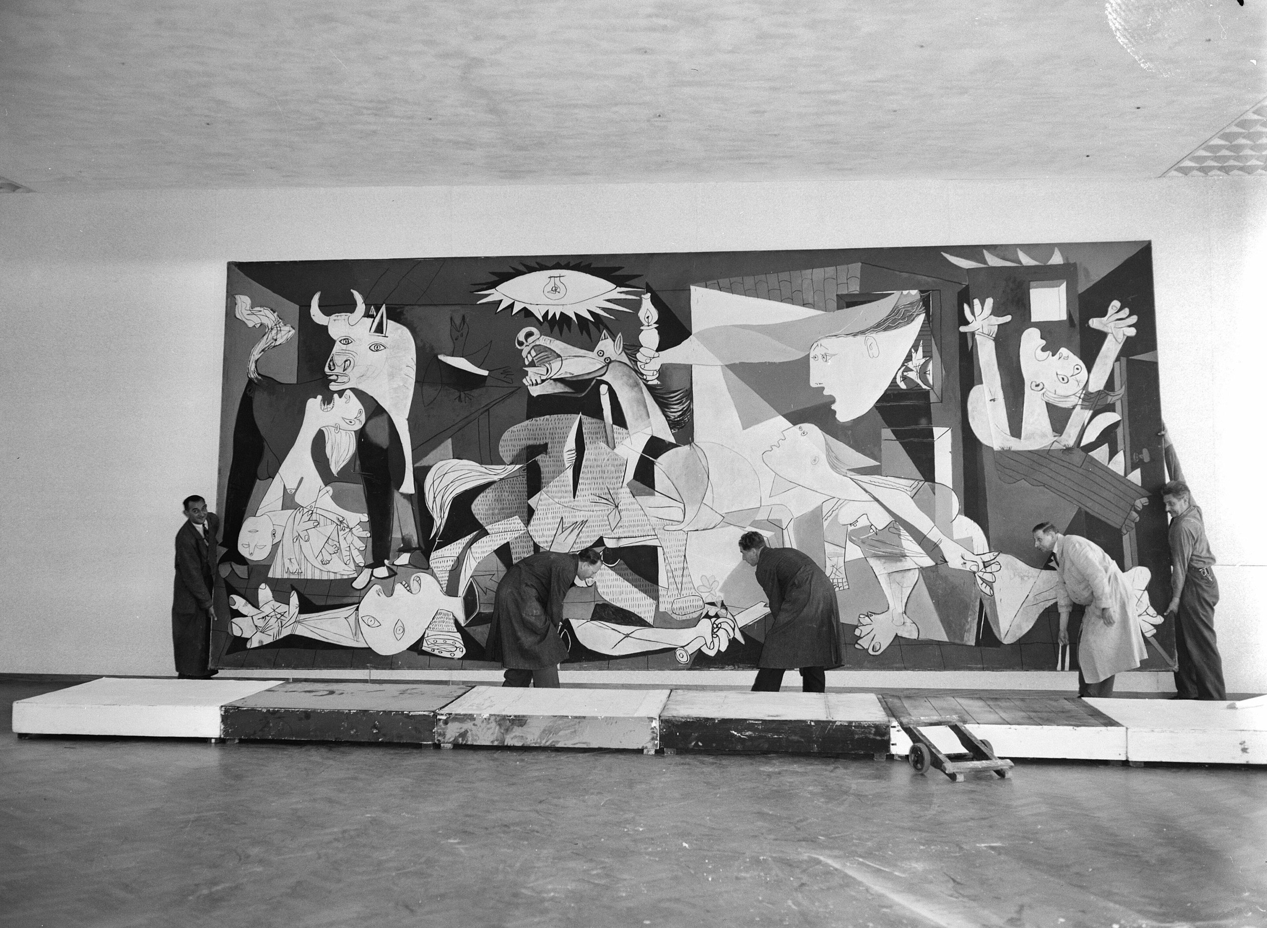 A monochrome image capturing individuals engaged in creating famous works of art.
