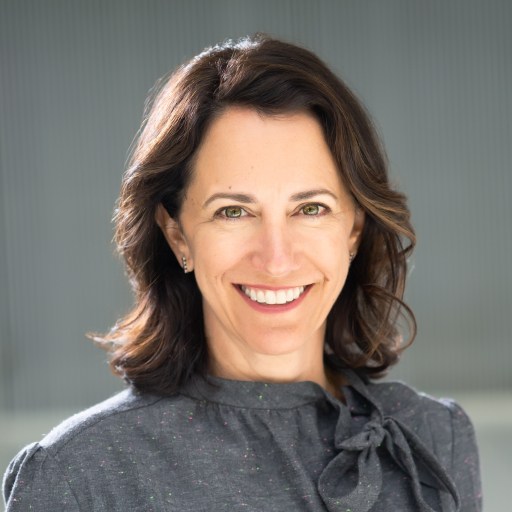 A smiling woman in a gray shirt.