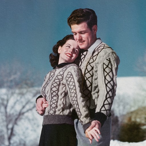 A man and woman wearing sweaters standing in the snow, showcasing how opposites attract.