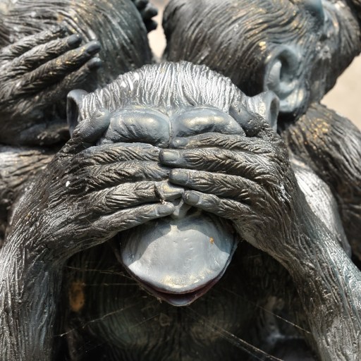 A statue of three monkeys covering their faces.