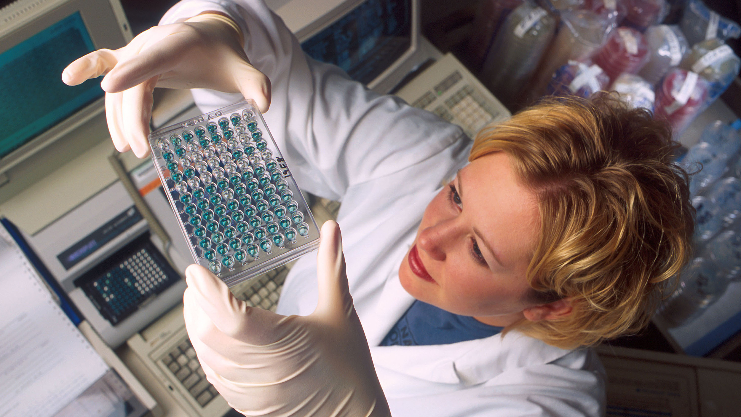 A woman wearing a lab coat researching non-hormonal birth control options.