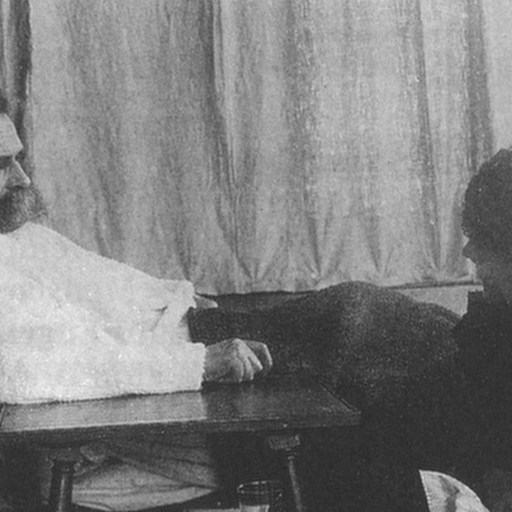 A man sitting in a chair next to a woman, pondering Friedrich Nietzsche's philosophy.