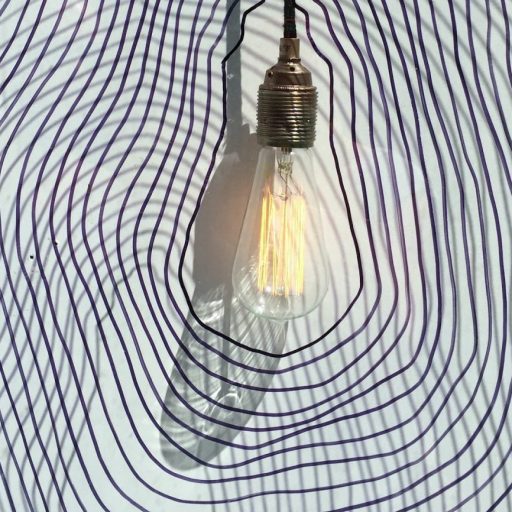 A light bulb hanging on a wall with a swirl pattern.