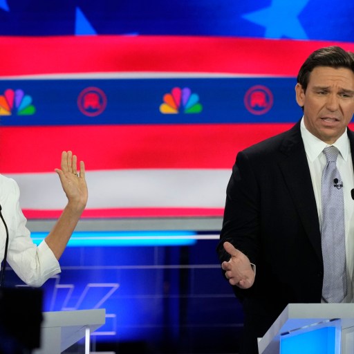 A man and woman standing at a podium in front of an american flag.