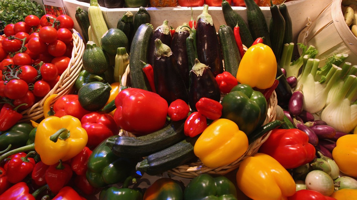 The baskets are filled with different kinds of vegetables.