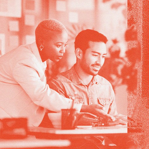 A man and woman demonstrating emotional intelligence while sitting at a table with a laptop.