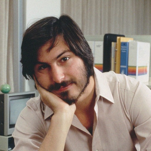 Steve Jobs in his office, showcasing survivorship bias in his journey of founding and leading Apple.