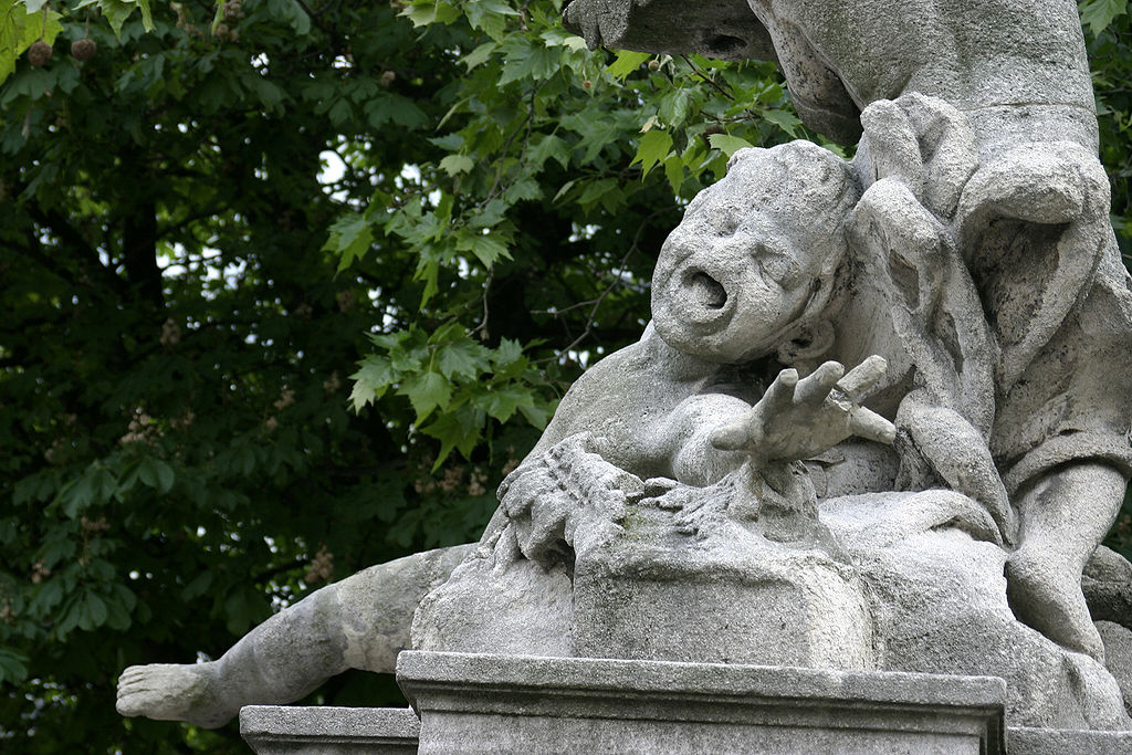 A statue of a child on top of a tree.
