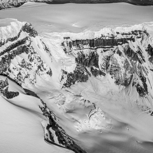 A black and white photo of a snow covered mountain.