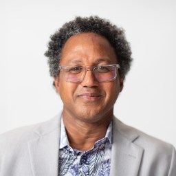 A man wearing glasses and a jacket.