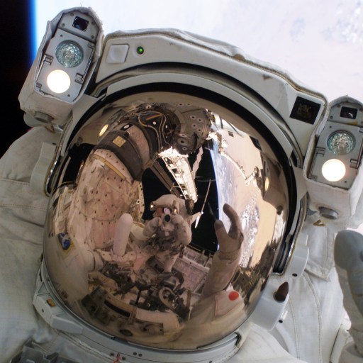 A man in an astronaut suit is waving to the camera, showcasing his leadership as he navigates outer space.