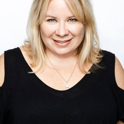 A blonde woman in a black top posing for a photo.