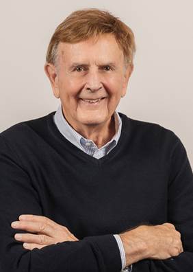 A man in a black sweater with his arms crossed.