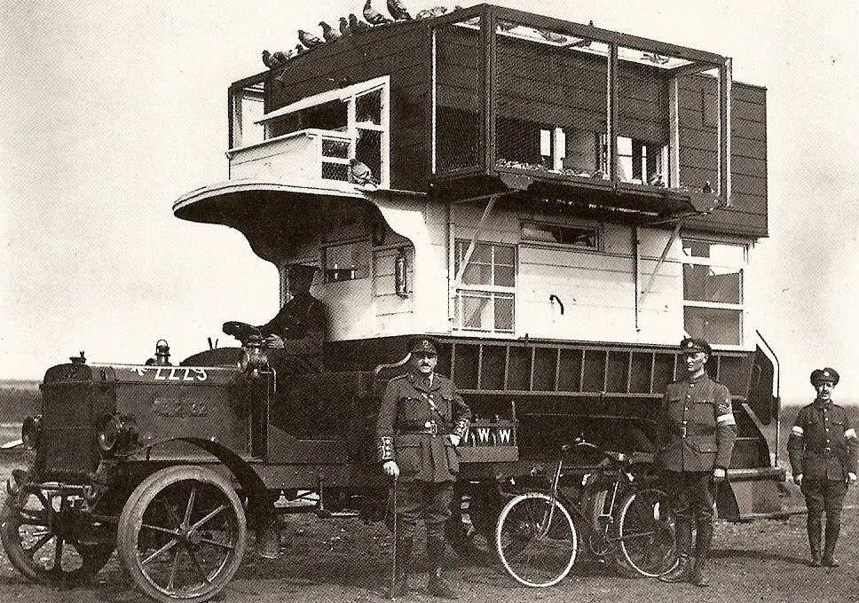 Description: Two men standing next to a truck with a Tesla on it.