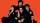 A group of people posing in front of an orange background.