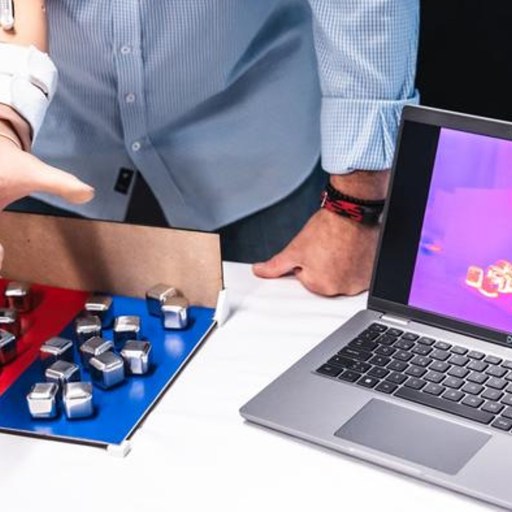 A person standing next to a laptop.