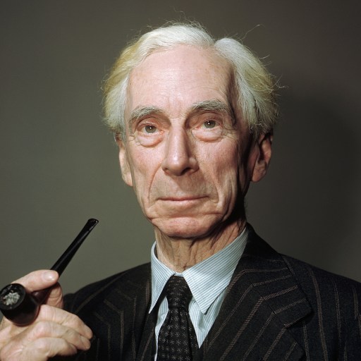 A man in a suit is holding a pipe, presenting an air of sophistication.