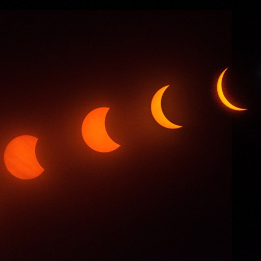 A sequence showing the phases of a solar eclipse, culminating in totality, against a dark background.