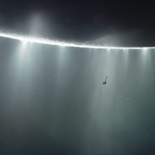 A spacecraft hovers near a bright ring of light in space, surrounded by misty rays and a vast, dark background.
