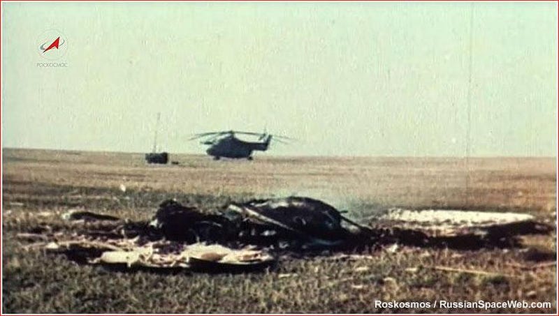 A helicopter rests on a grassy field with debris scattered in the foreground, evoking the USA's race to outpace the USSR under a clear sky.