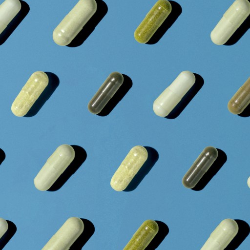 Various capsules arranged diagonally on a blue surface, alternating between light and dark colors.