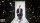 A person in a suit sits on a chair against a cosmic background with galaxies and stars.