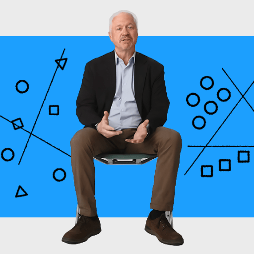 A person sits on a stool against a blue background with black and white geometric diagrams, including lines, circles, squares, and triangles.