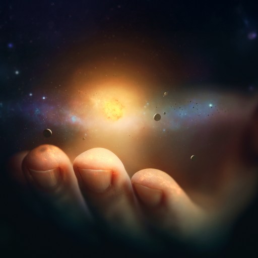 A human hand appears to hold a glowing celestial object surrounded by small planets and stars, creating the illusion of a miniature universe in the palm.