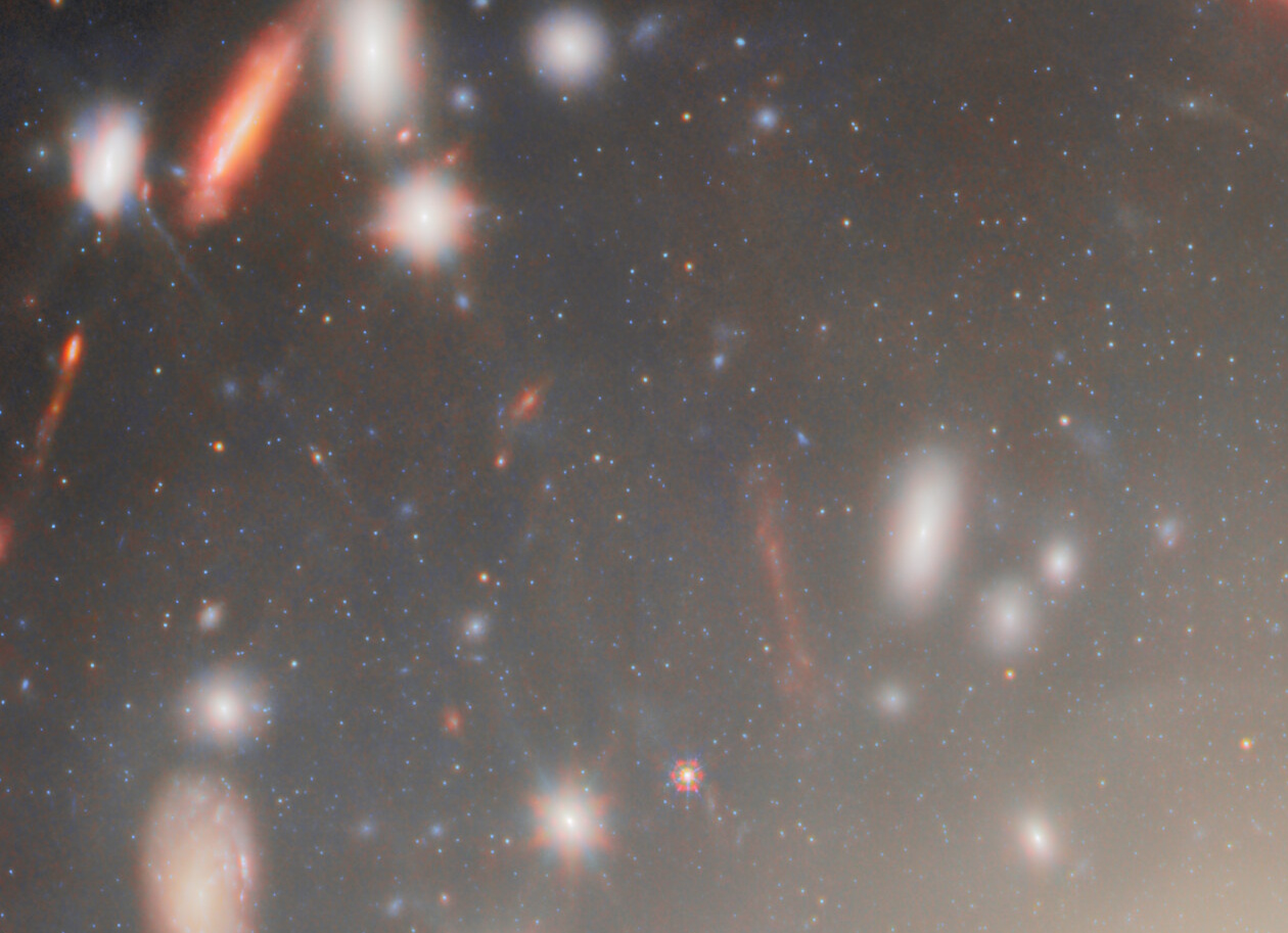 A field of distant galaxies and stars, captured by JWST, showcases some objects blurred by motion or distance—revealing the most extreme gravitational lens in the cosmos against a dark background.