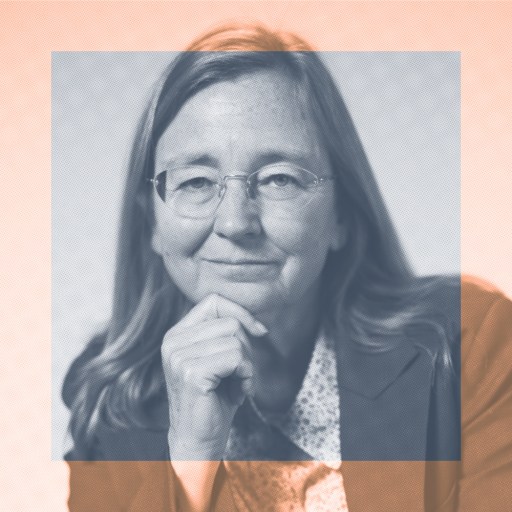 A woman with long hair and glasses wearing a blazer, posed with her hand under her chin, looks at the camera. The photo is overlaid with a semi-transparent colored square.