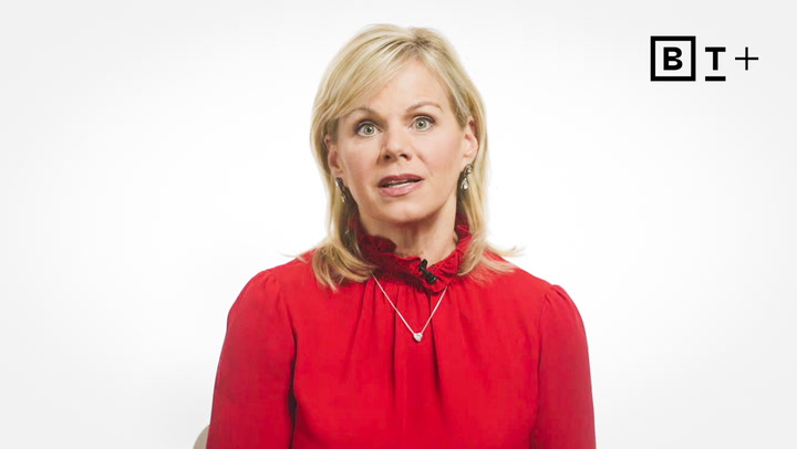 A woman with blonde hair wearing a red blouse and necklace sits in front of a white background with a "BT+" logo in the top right corner.