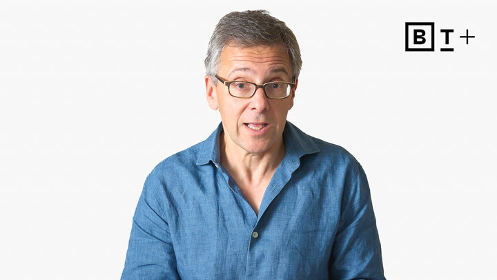 A middle-aged man with glasses and a blue shirt speaks while facing the camera. The background is plain white with a "BT+" logo in the upper right corner.