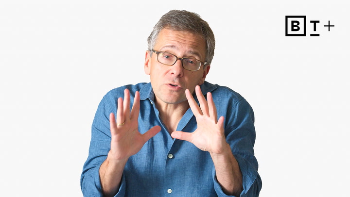 A man in glasses and a blue shirt gestures with his hands, facing the camera. The letters "BT+" appear in the top right corner on a plain background.