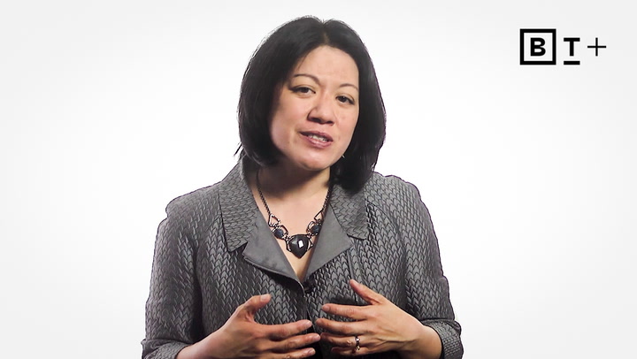 A woman with shoulder-length dark hair wearing a gray textured jacket and necklace speaks, with a "BT+" logo in the top right corner on a plain white background.