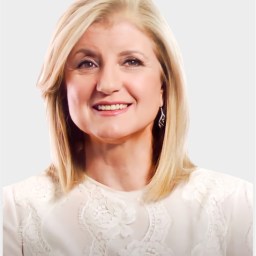 A woman with shoulder-length blonde hair, wearing a white lace top, smiles at the camera against a plain light background.