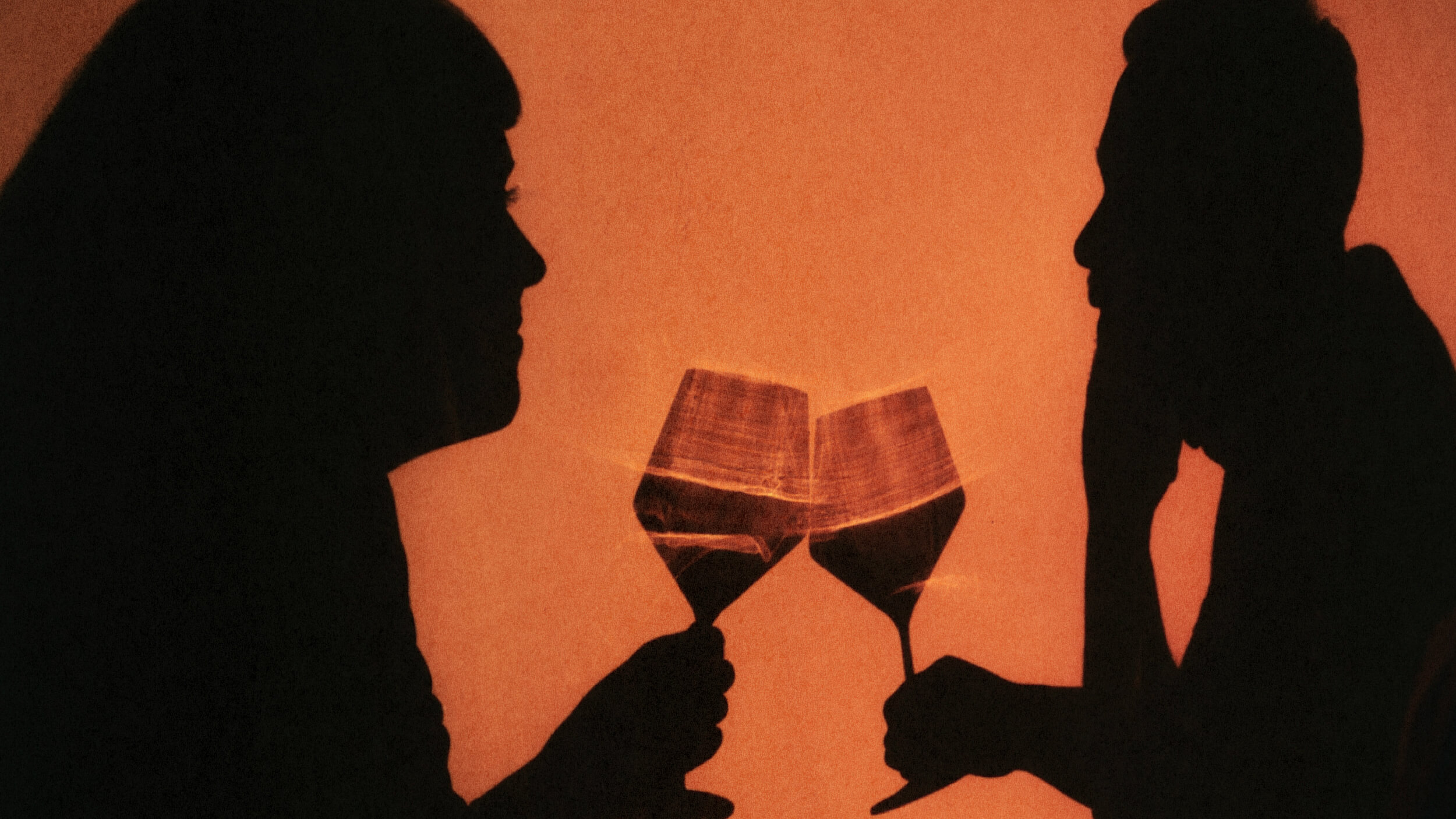 Silhouettes of two people facing each other, clinking wine glasses against an orange background, sharing a lighthearted, possibly drunk moment.