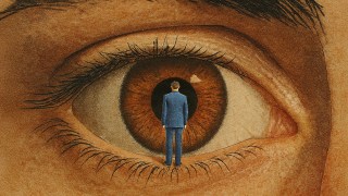 A man in a suit stands facing a large human eye, positioned at the center of the pupil as if about to step inside.